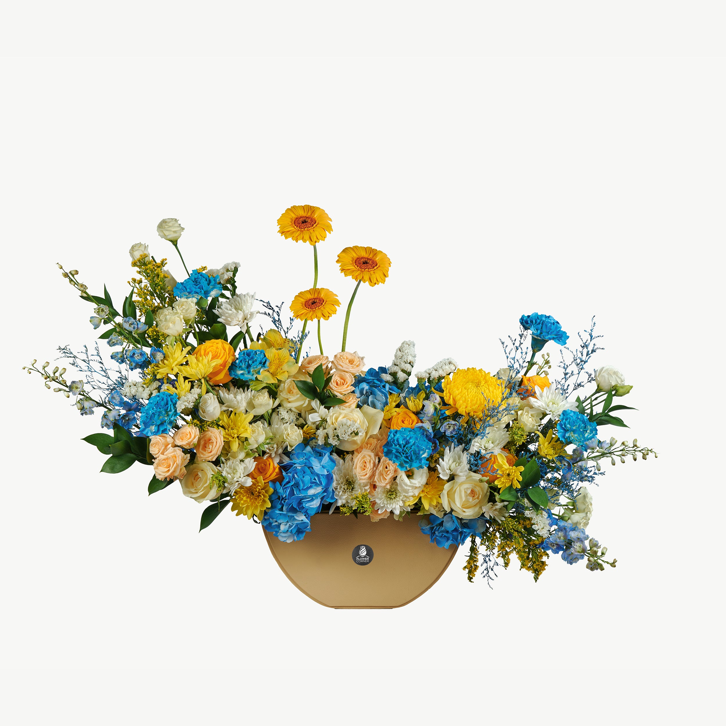 Blue, yellow, and white blooms with greenery in a luxurious leather base.