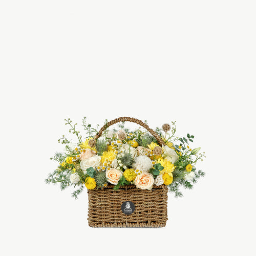 Bloom Bliss flower basket with yellow and peach seasonal flowers and greenery